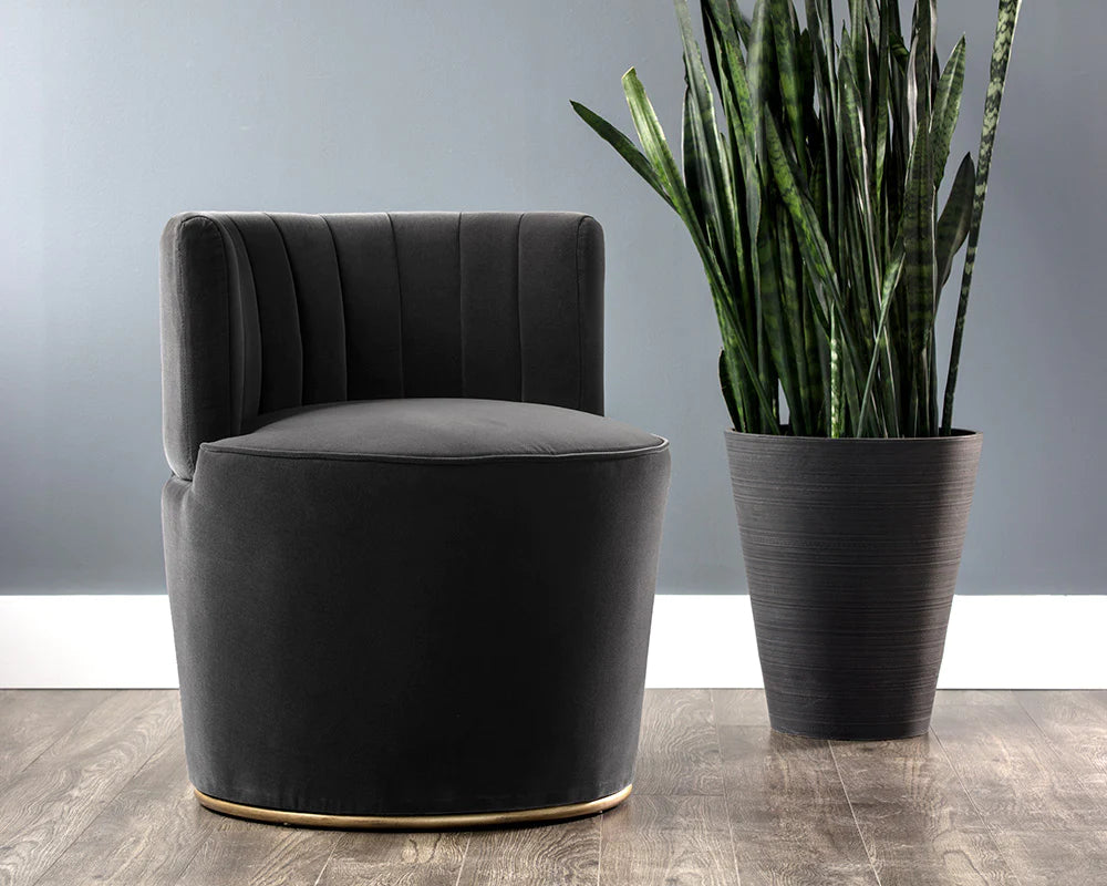 A stunning lounge chair that effortlessly elevates any setting, crafted in a luxurious dark charcoal gray fabric and antique brass base. Lifestyle view.